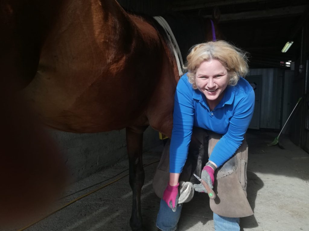 Woman trimming horse hoof